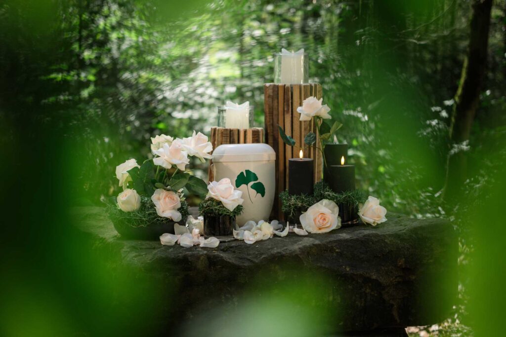 Albatros-Bestattungen® Beispiel Friedwald Beisetzung Blumen, Urnen und Kerzen